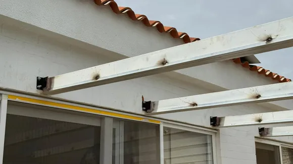 Detalle de cubierta tipo sándwich en pérgola metálica — vista inferior de la estructura terminada en Jamundí